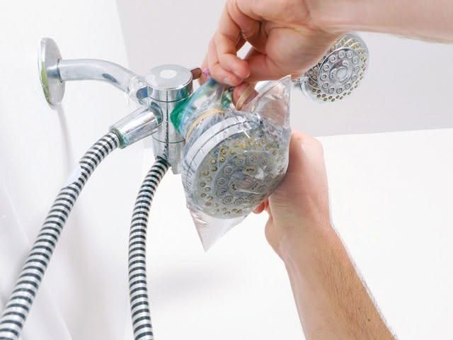Removing limescale from showerhead with vinegar soak in UAE hard water